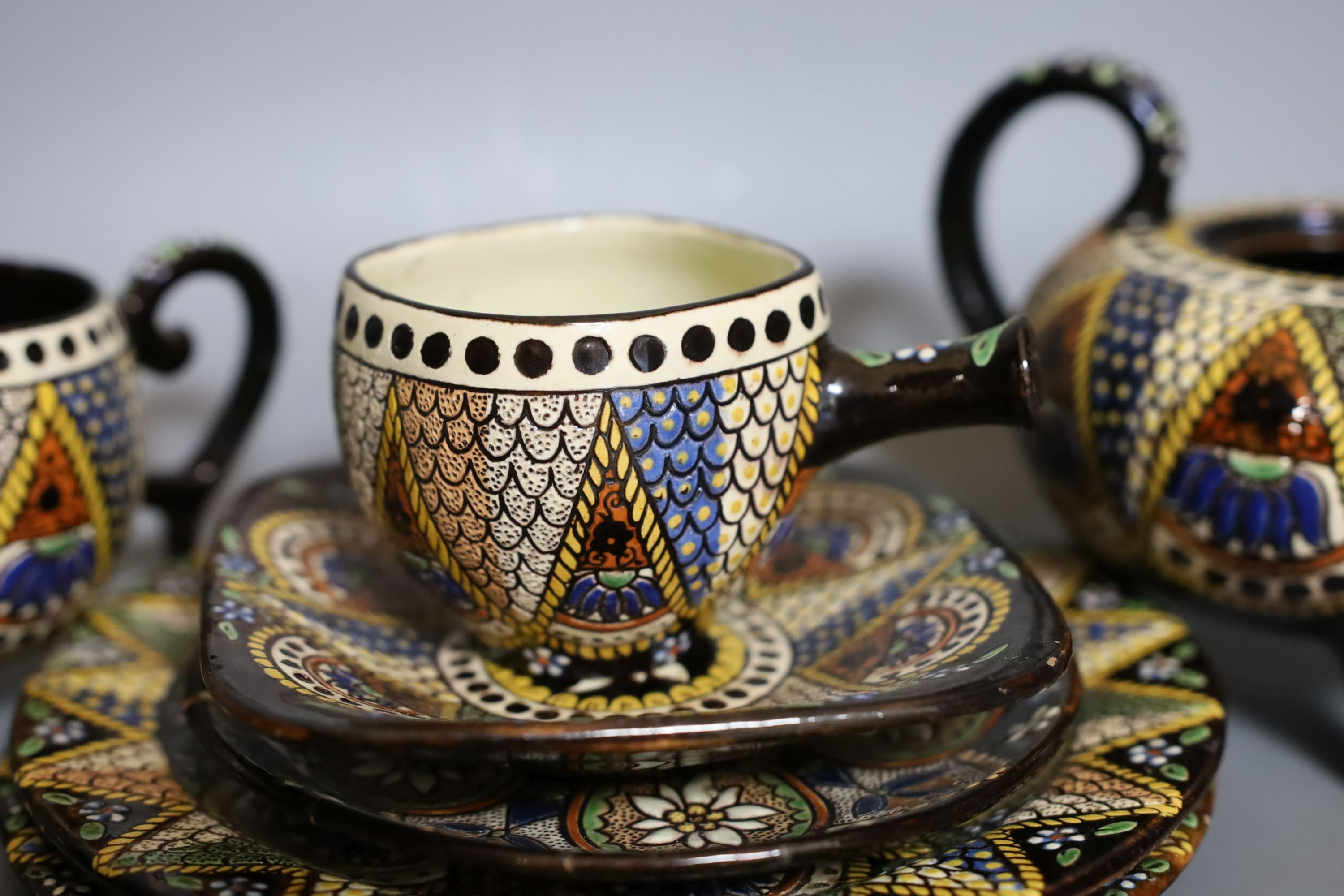 A Swiss Thoune treacle glazed incised pottery tea set, with coloured decoration (8)